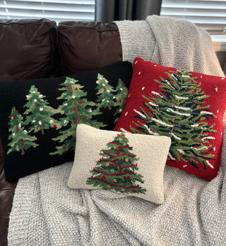 Red holiday pillow showcasing hand-hooked craftsmanship on a sofa