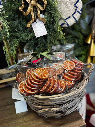 Basket of dried orange slices with a Christmas wreath in the background