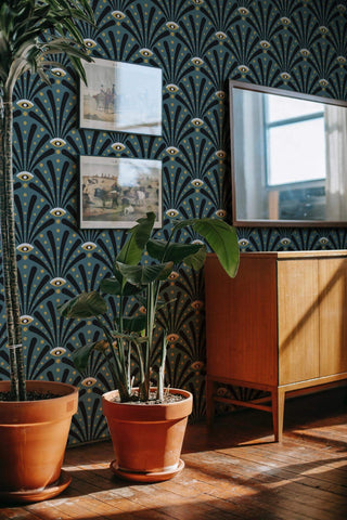 Image of living room with tv and midcentury modern style tv stand with green and black art deco eyes contact paper as wallpaper.