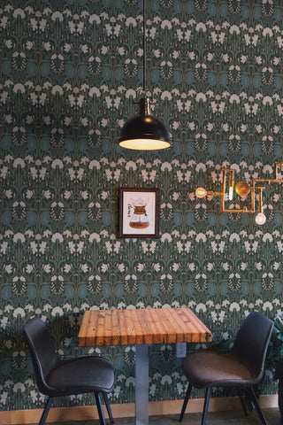 Cafe scene with green, gold, and cream floral wallpaper